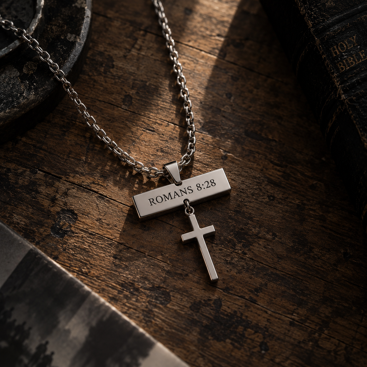 Close-up of the engraved bar pendant resting on dark wood beside a Bible